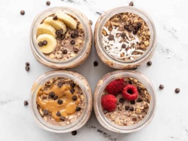 Overhead view of four jars of chocolate overnight oats, each with a different topping