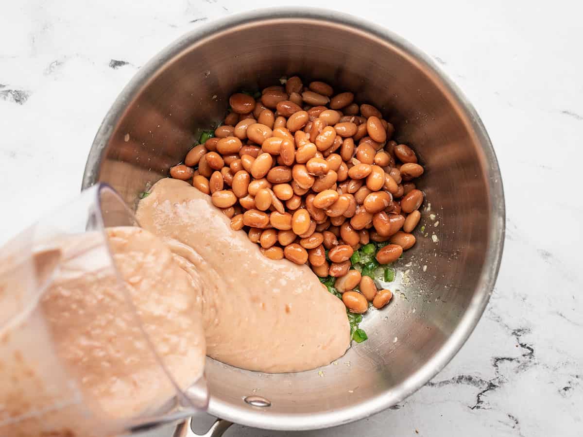 Pinto beans in the pot, puréed beans being poured into the pot.