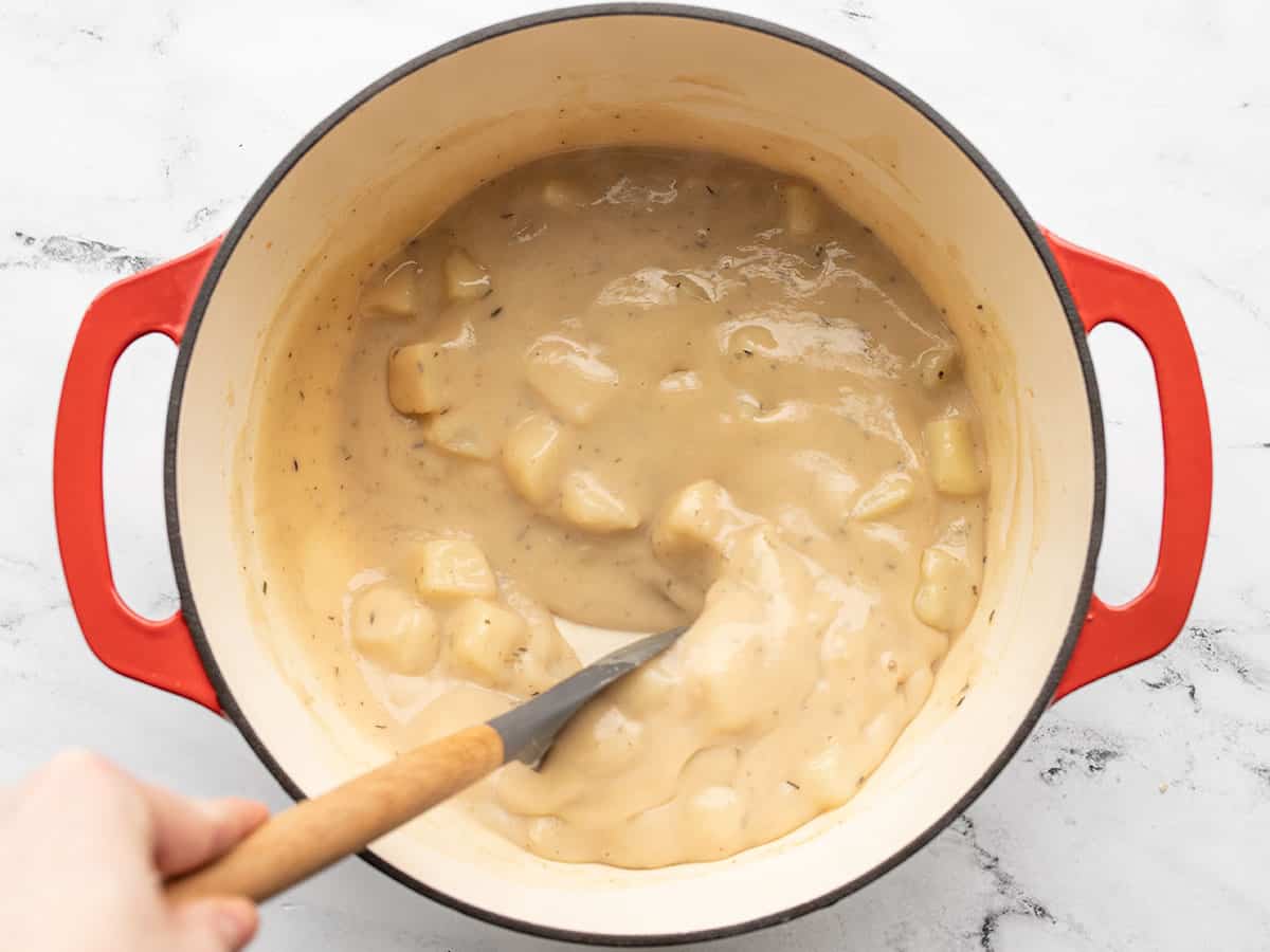 Thickened gravy being stirred in the pot.