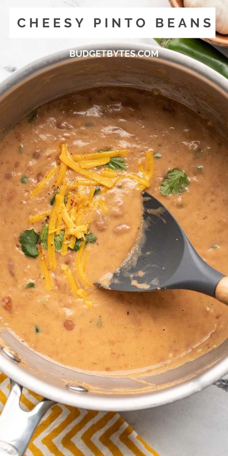 Overhead view of a pot of cheesy pinto beans.