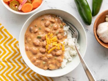 Overhead view of a bowl of cheesy pinto beans over rice.