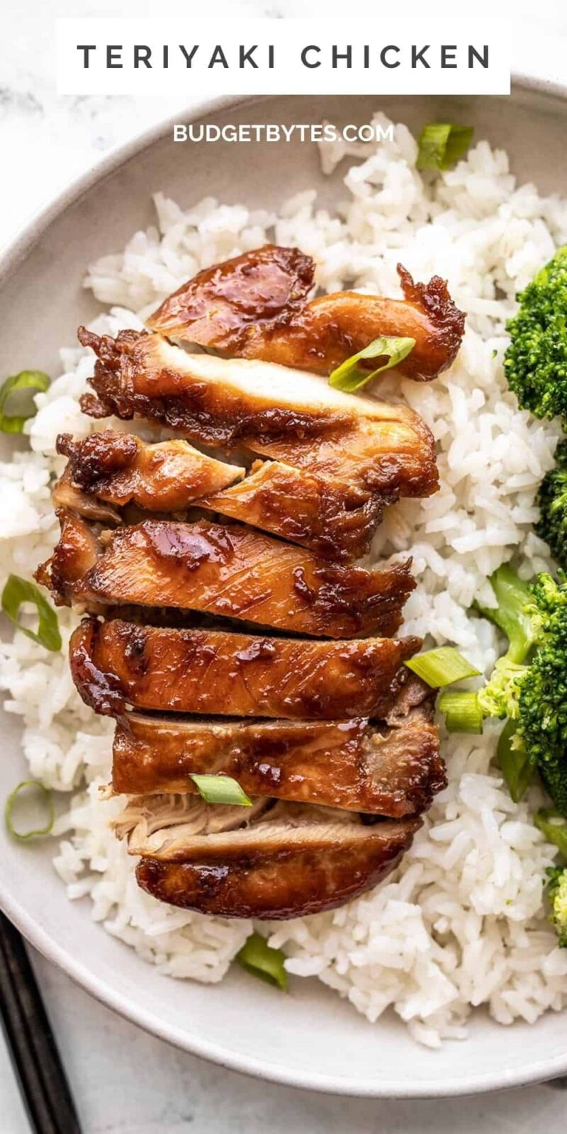 Sliced teriyaki chicken on a bed of rice with broccoli on the side.