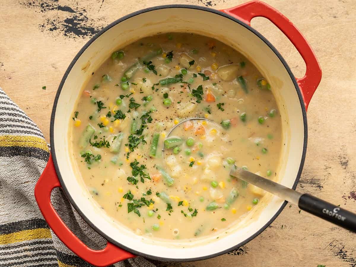 Overhead view of a pot full of vegetables and gravy.