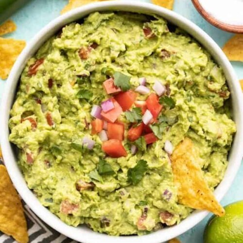 close up of guacamole in the bowl with a chip.