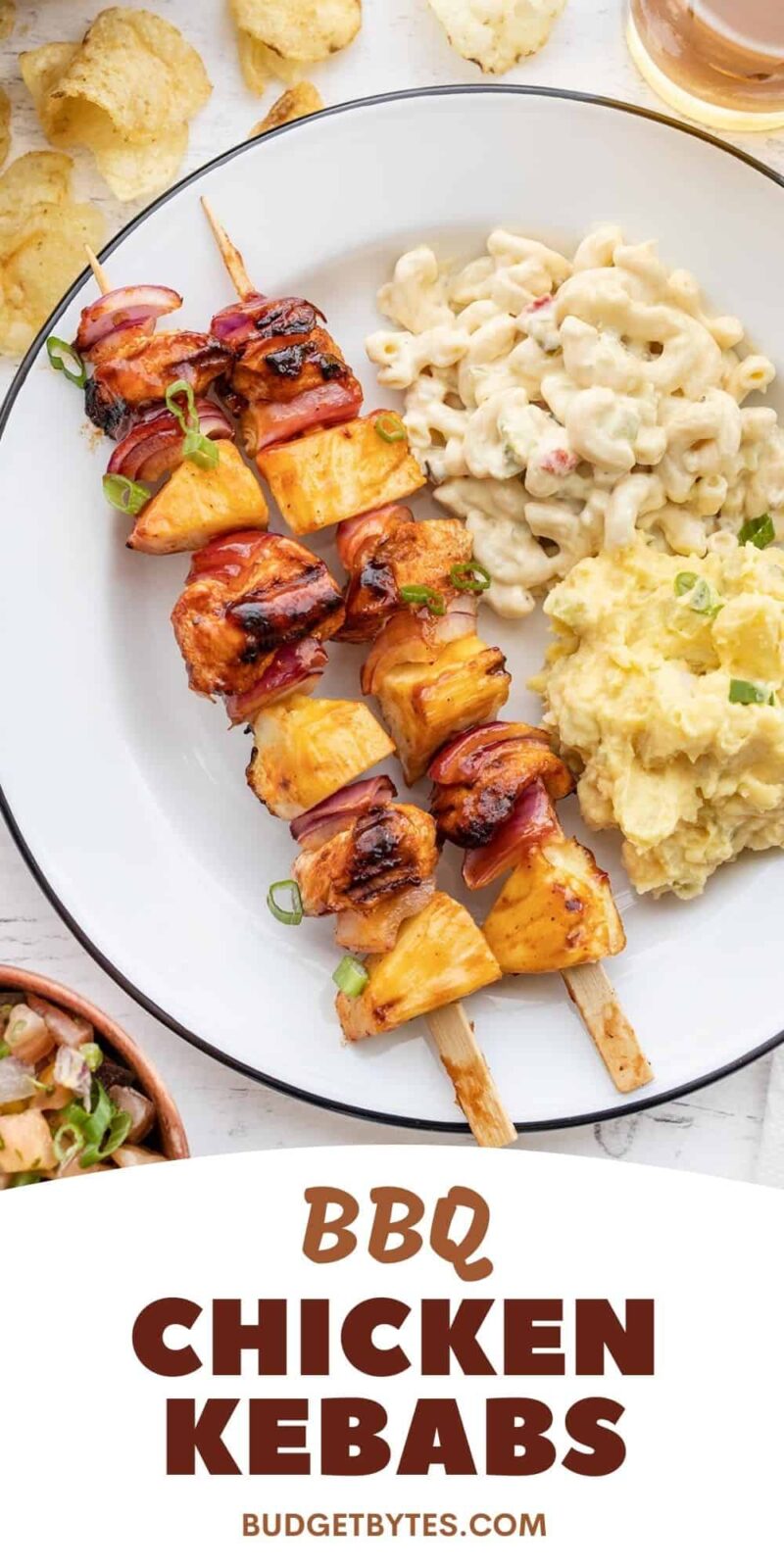 A plate with two BBQ Chicken Kebabs, macaroni salad, and potato salad.