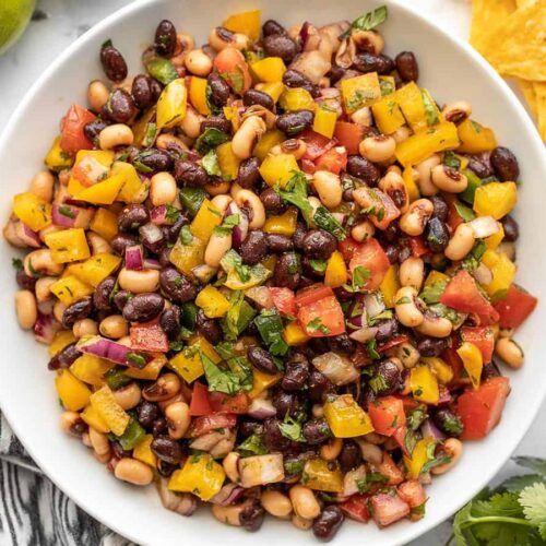 Close up overhead view of cowboy caviar in a bowl with chips on the side.