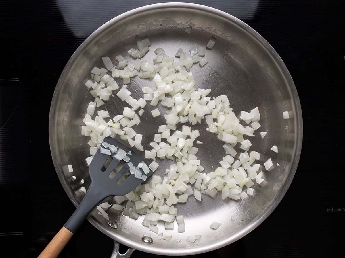 Sautéed Onion in the skillet with a spatula.