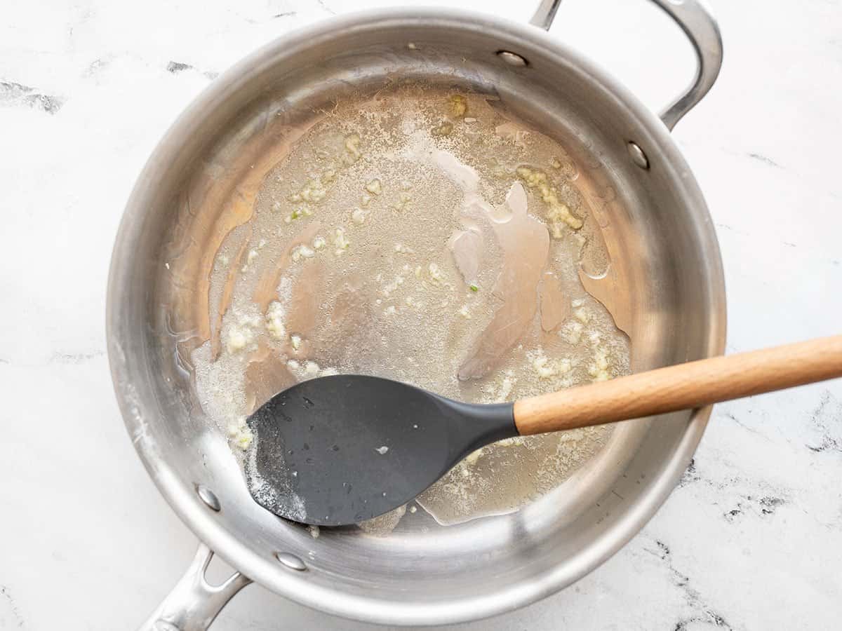 Sautéed garlic in butter in a skillet.