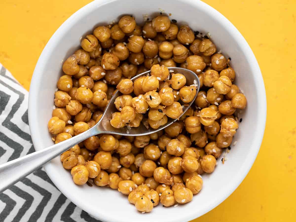 Close up overhead view of a bowl full of air fryer chickpeas with a spoon.