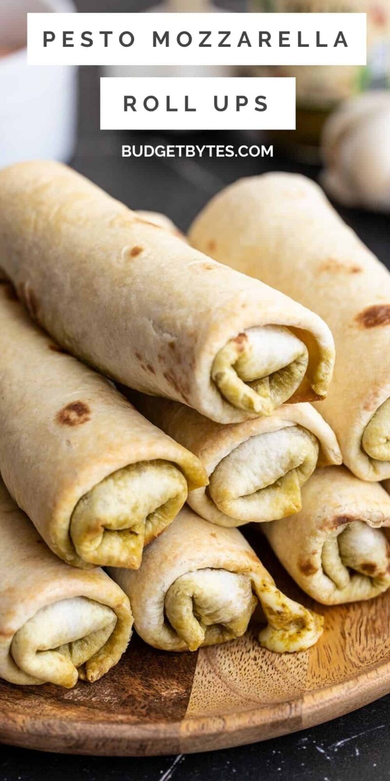 Side view of a plate stacked with pesto mozzarella roll ups.