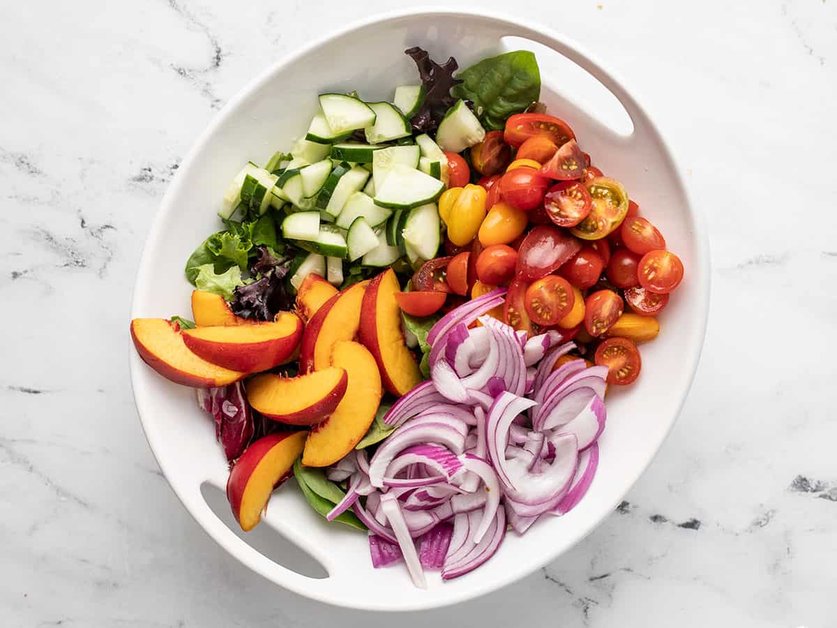 Overhead shot of panzanella salad components.in a white bowl.