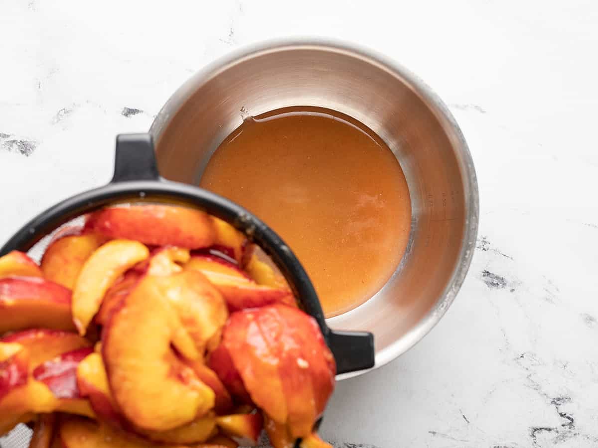 Overhead shot of peach juice being strained into a pot.