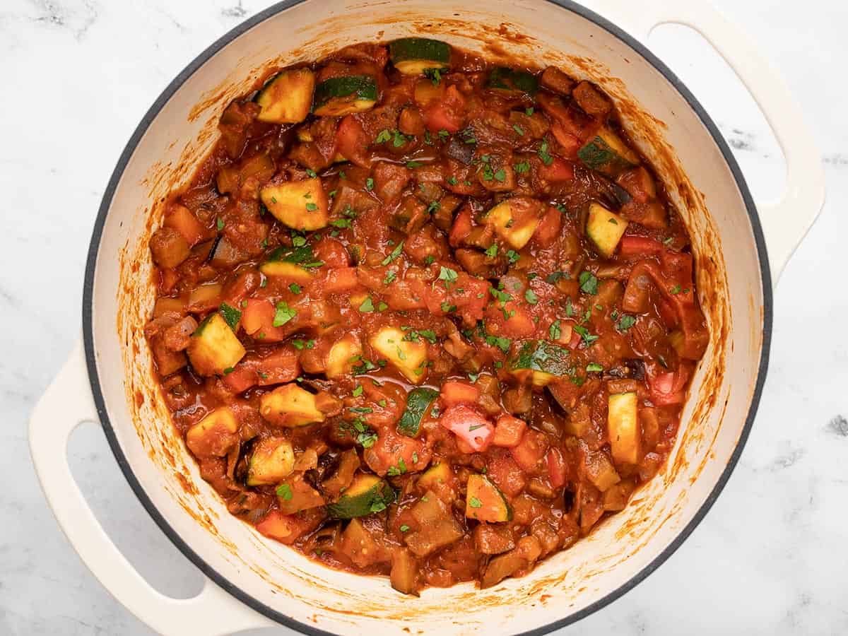 Overhead view of vegetables in red sauce in the pot.