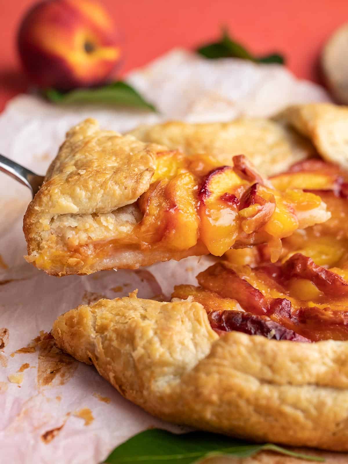 Side shot of slice of peach galette on a pie spatula.