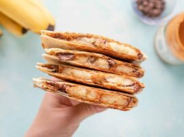 A hand holding a stack of peanut butter banana quesadillas.