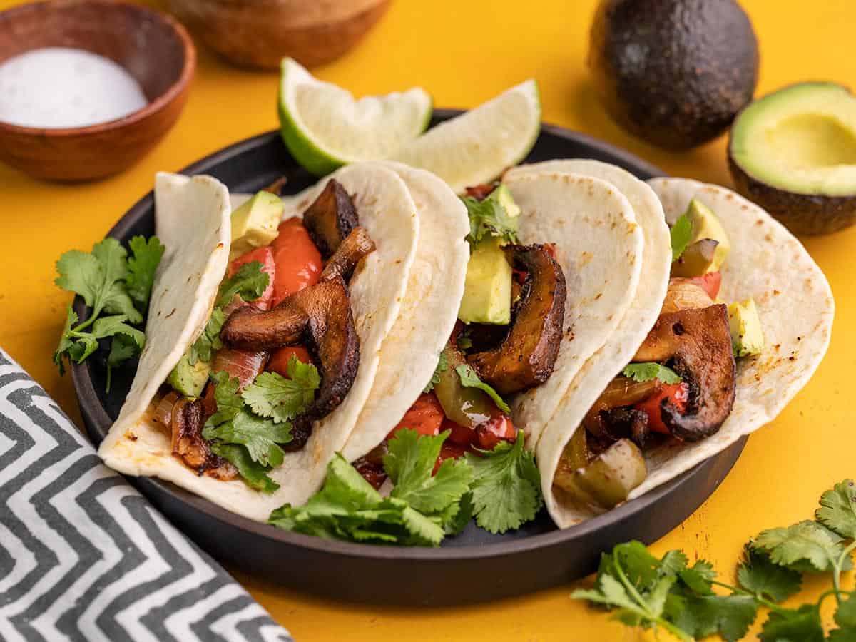 side view of three portobello fajitas on a plate.