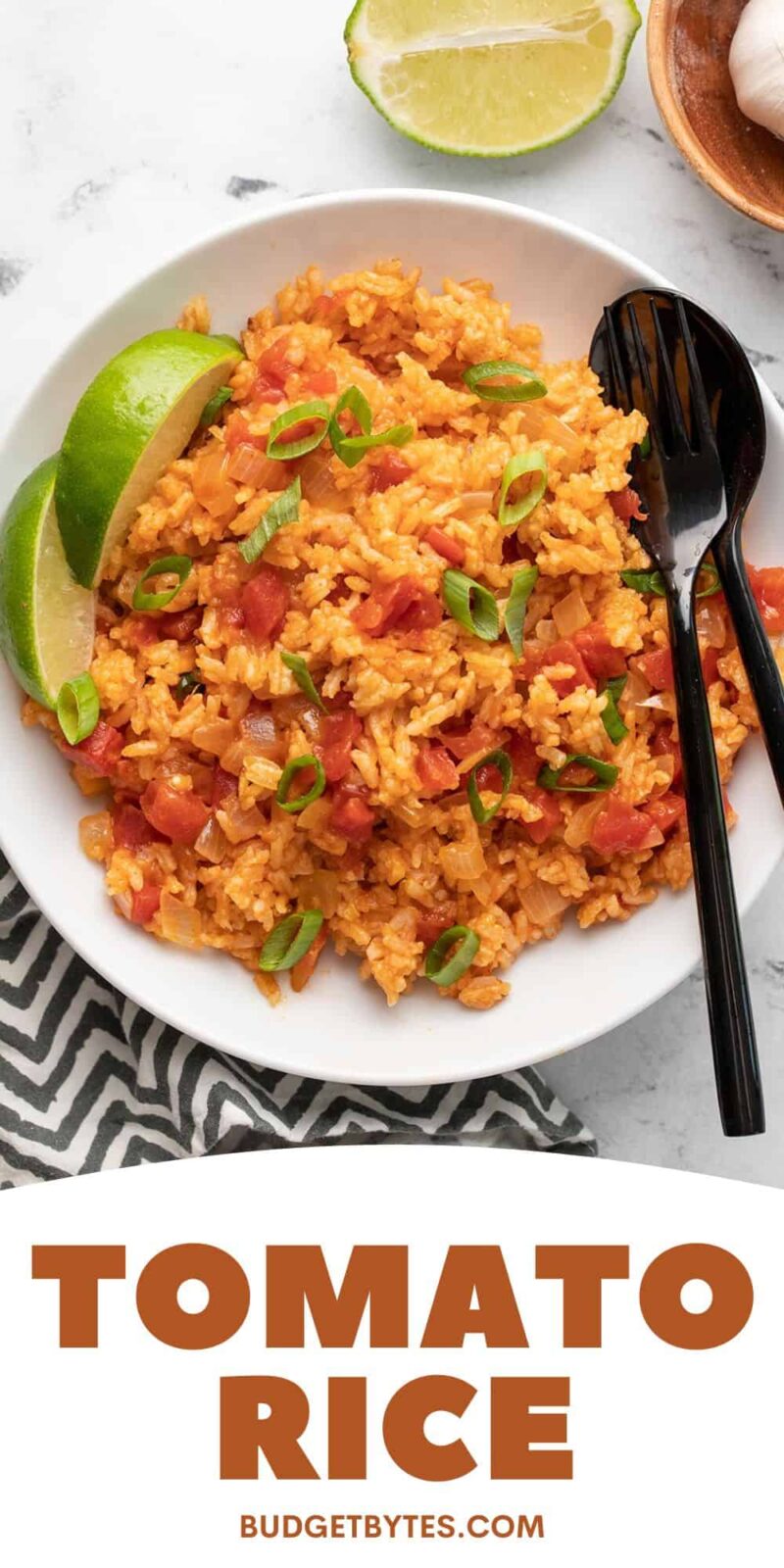 Overhead view of a bowl of tomato rice with lime.