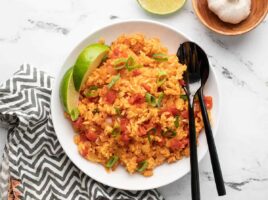 Tomato rice bowl topped with herbs and spices.