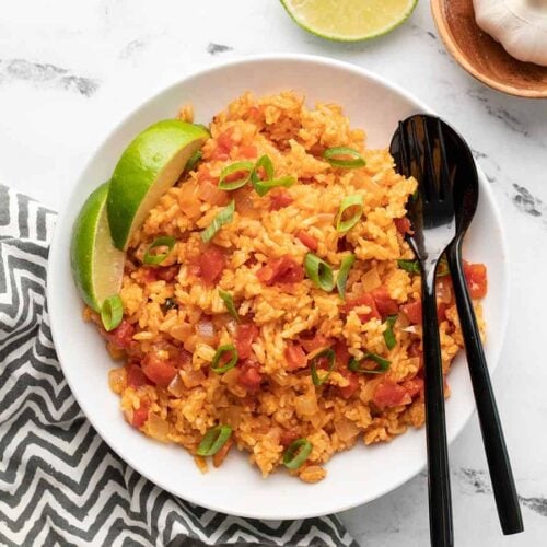 Tomato rice bowl topped with herbs and spices.