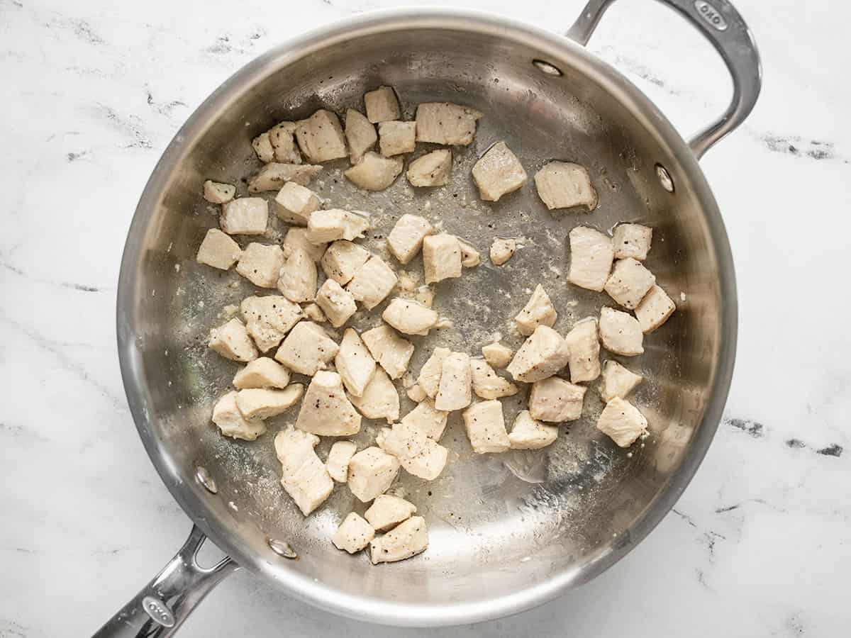 Cooked diced chicken in a skillet.