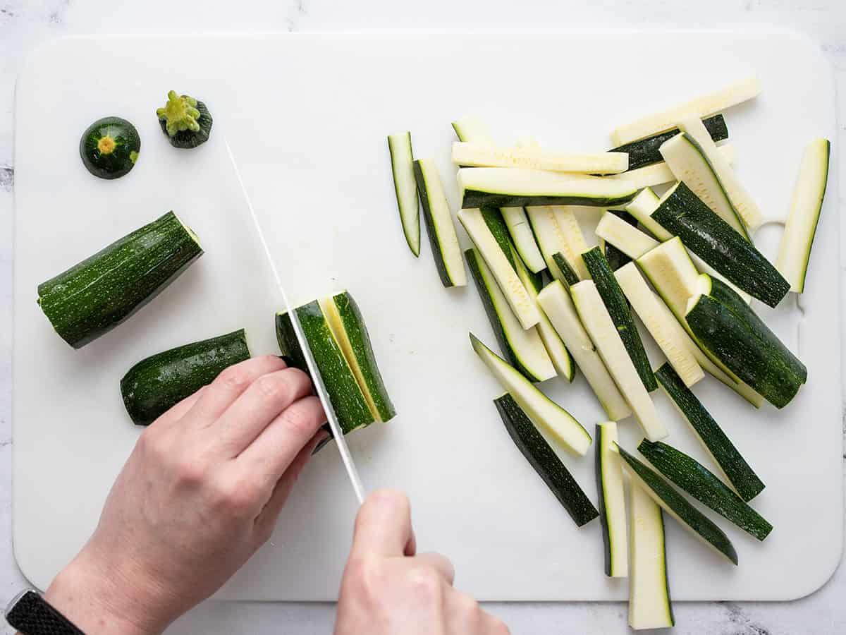 Zucchini being sliced into matchsticks.