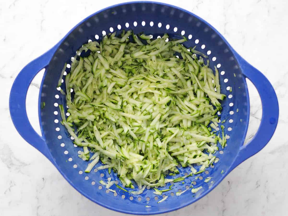 Grated zucchini in a colander.