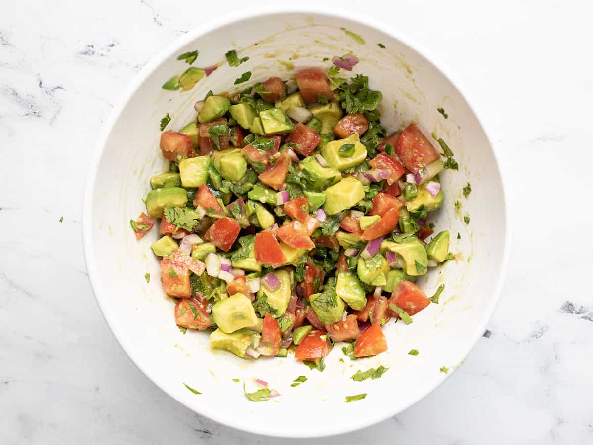 Stirred avocado tomato salad in the bowl.