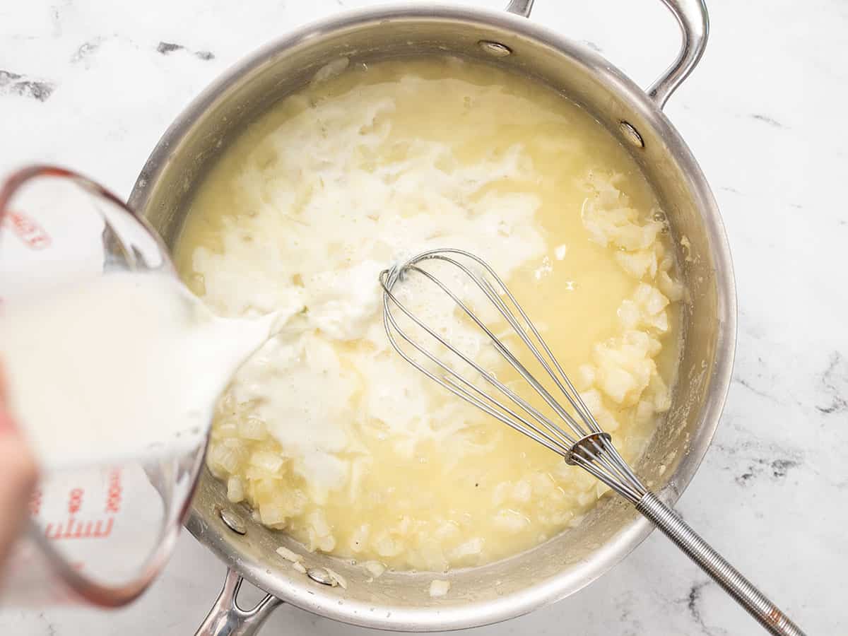 Milk and broth being added to the skillet.