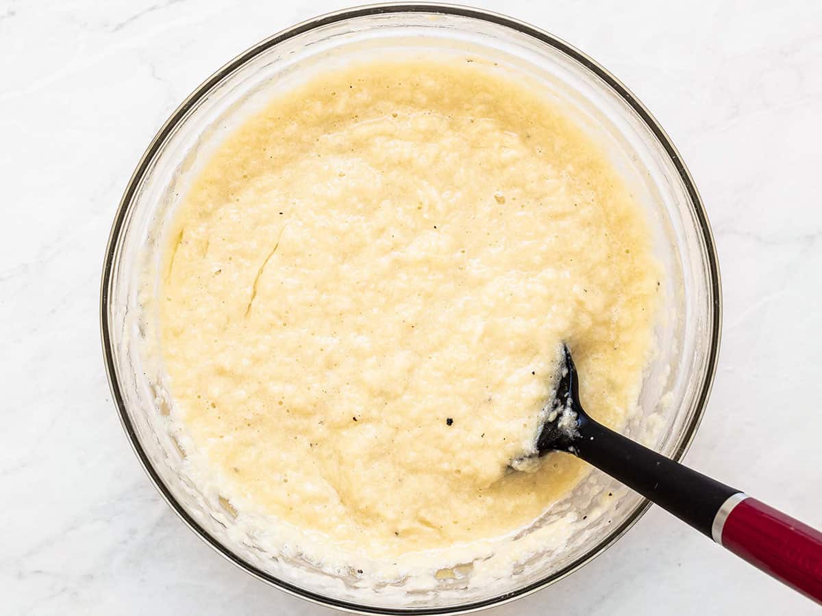 Potato pancake batter in a bowl with a spatula.