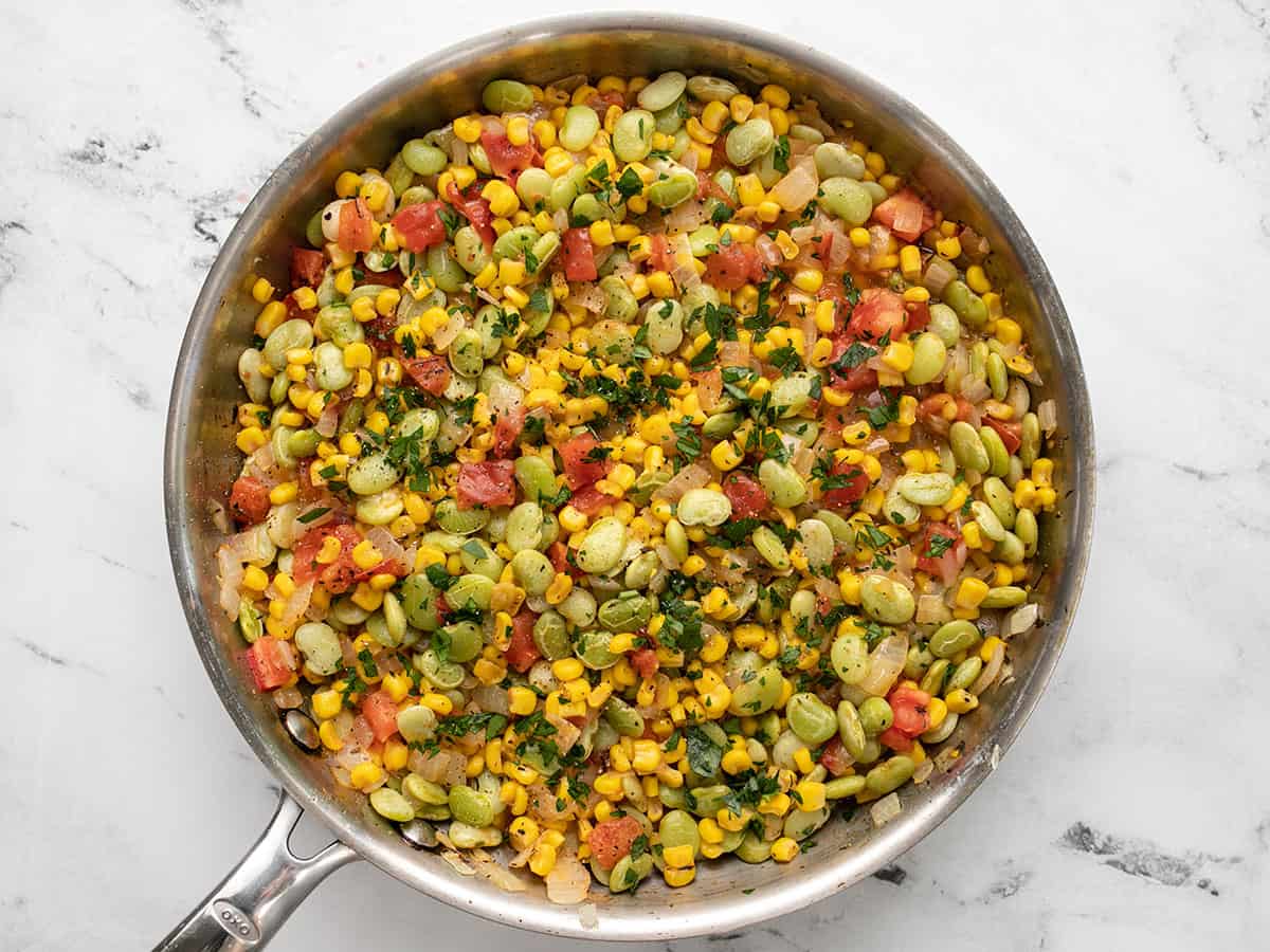 Finished succotash topped with parsley and pepper.