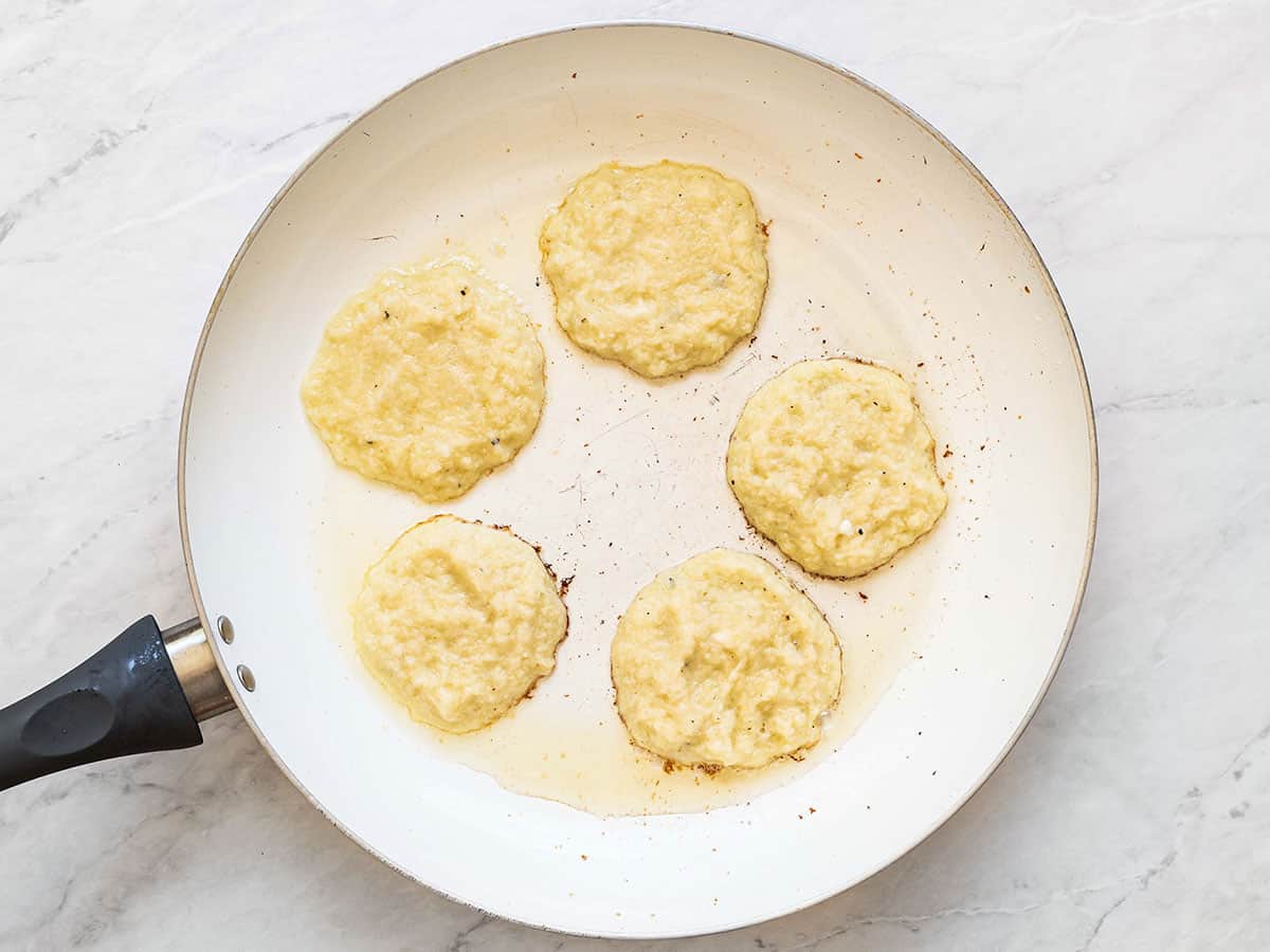 Potato pancakes in a skillet half-cooked.