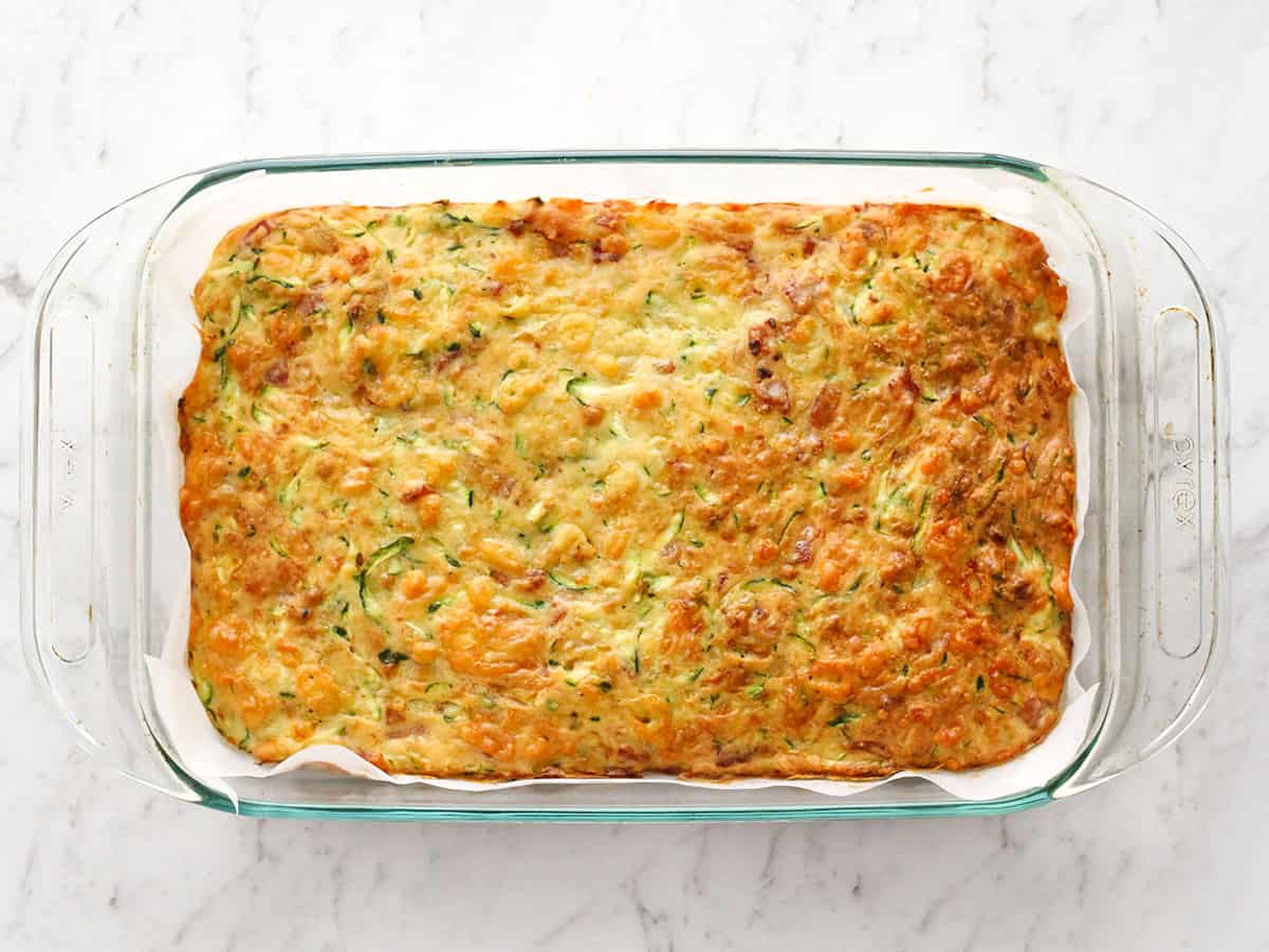 Baked zucchini slice in a glass casserole dish.