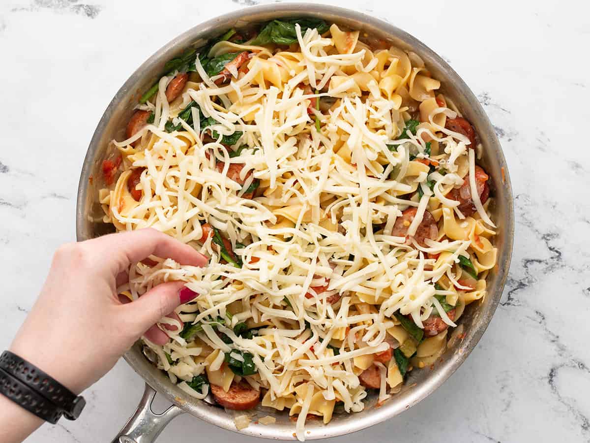 Cheese being added on top of the pasta. 