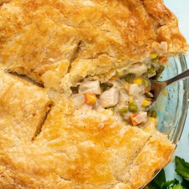 A slice of chicken pot pie taken out of the pie dish.