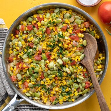 Overhead view of a skillet full of soccotash.