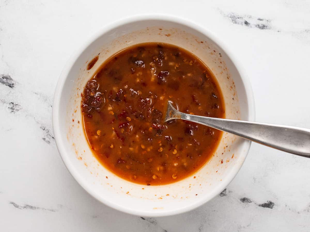 honey chipotle marinade in a bowl with a spoon.