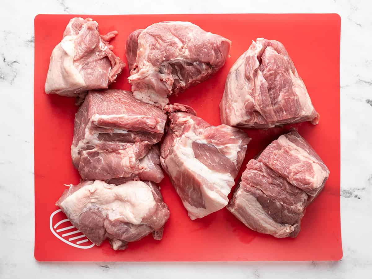 Chunks of pork butt on a cutting board.