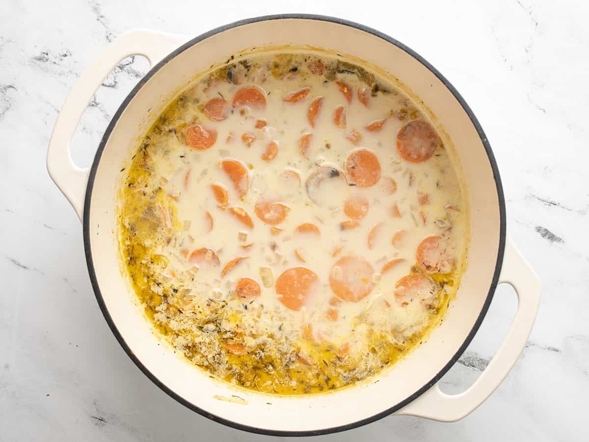 Overhead shot of carrots cooking in cream mixture.