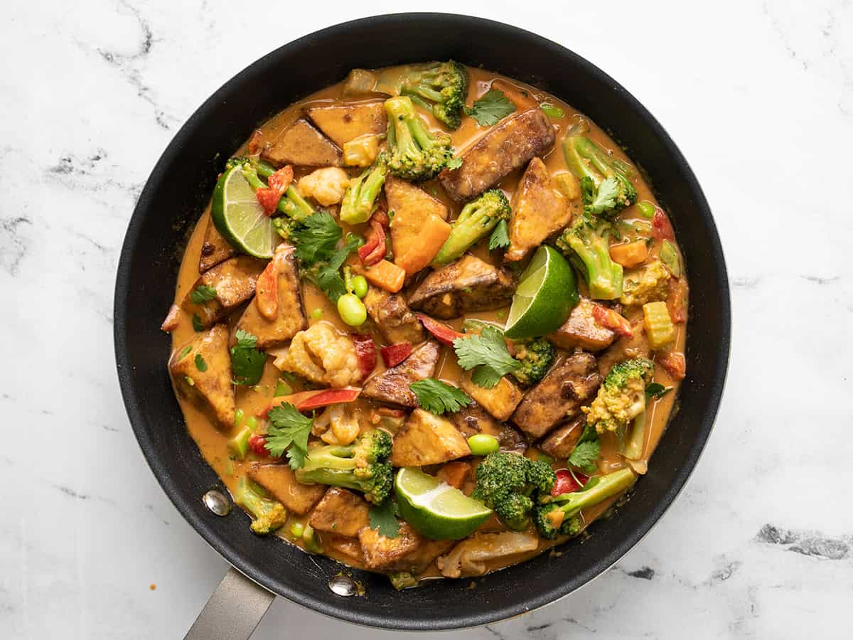 Finished peanut tofu in the skillet with limes and cilantro.