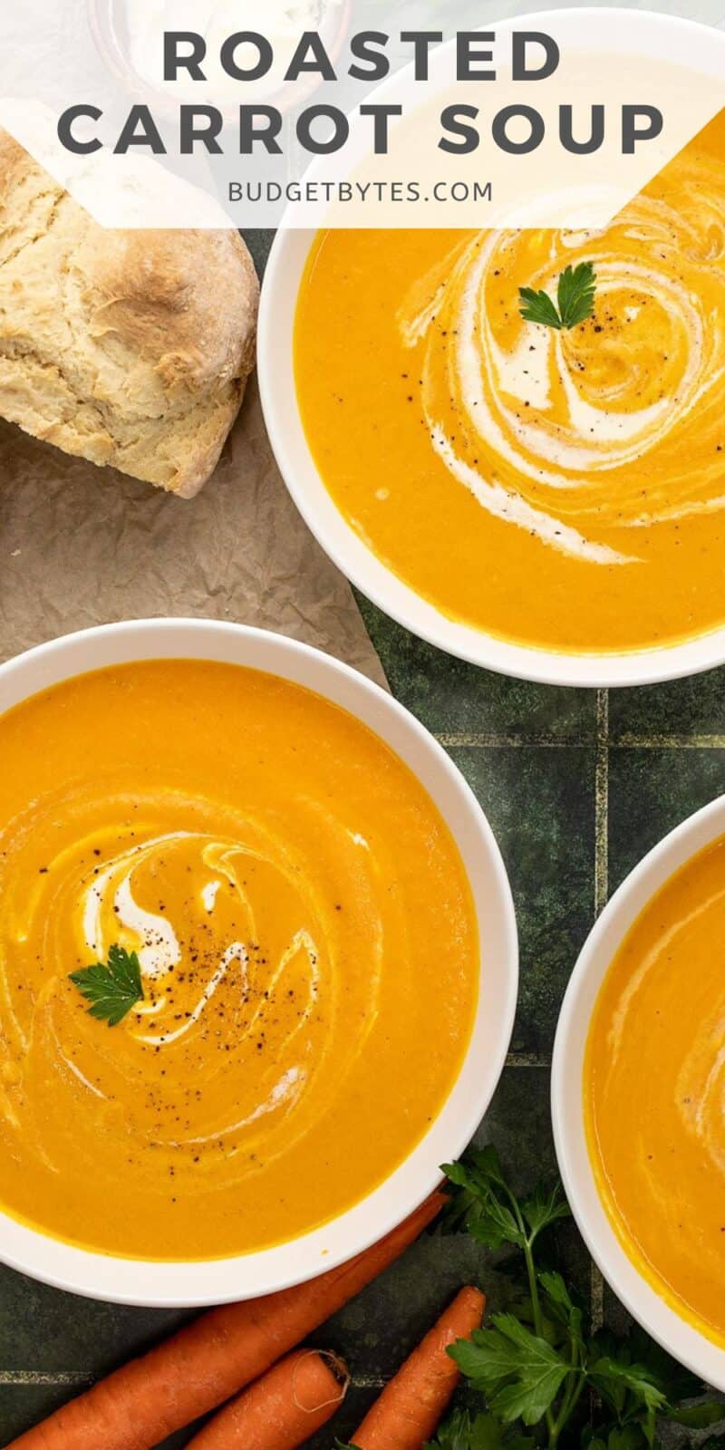 Overhead shot of carrot soup in a white bowl with sour cream swirled in it.