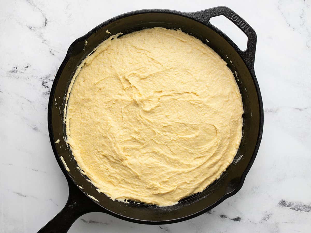 Overhead shot of cornbread batter in a cast iron skillet.