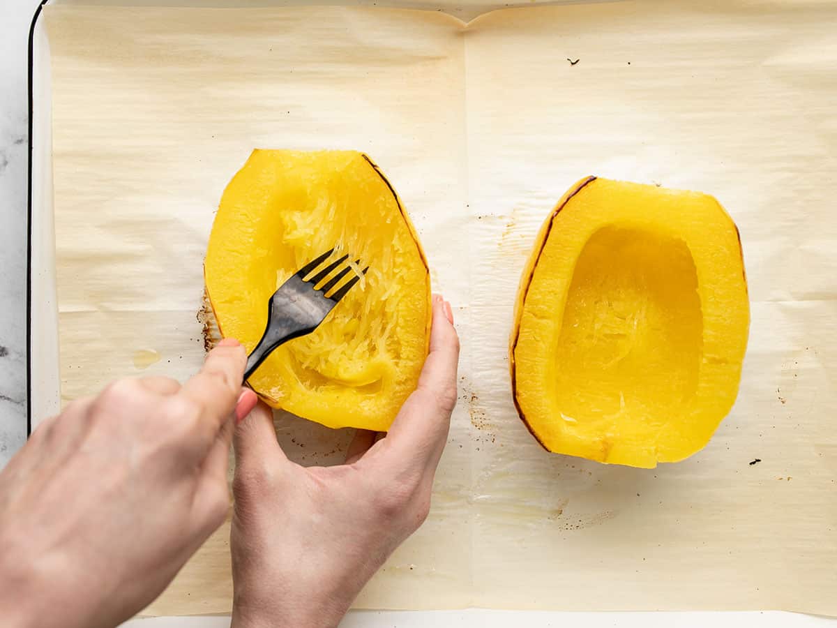 Overhead shot of fork scraping cooked Spaghetti Squash.