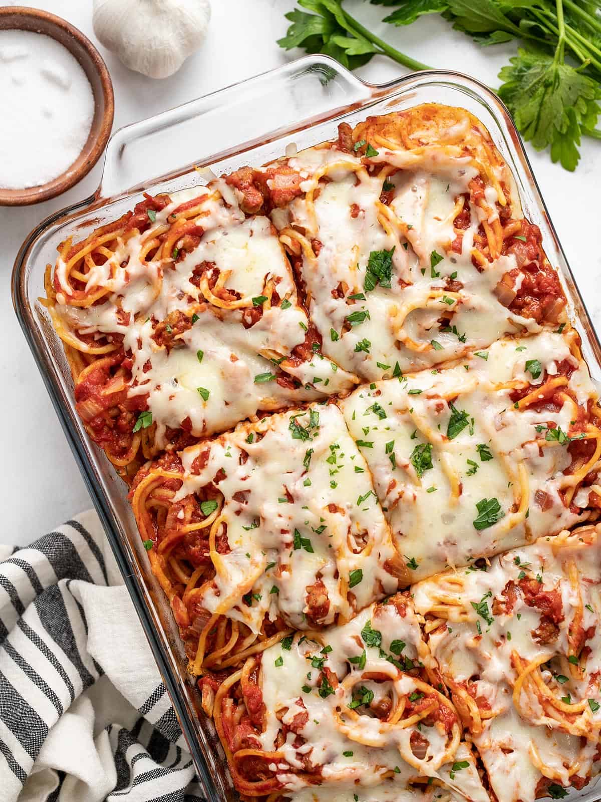 Overhead view of baked spaghetti in the casserole dish, sliced.