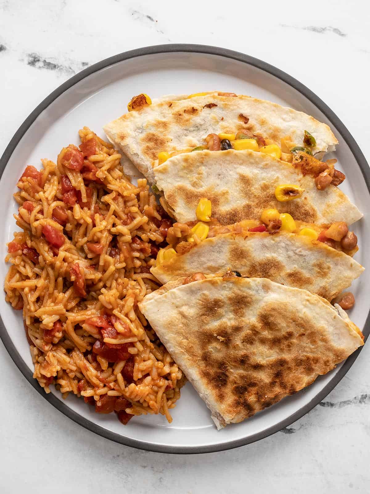 Overhead view of bean quesadillas on a plate with Spanish RIce.