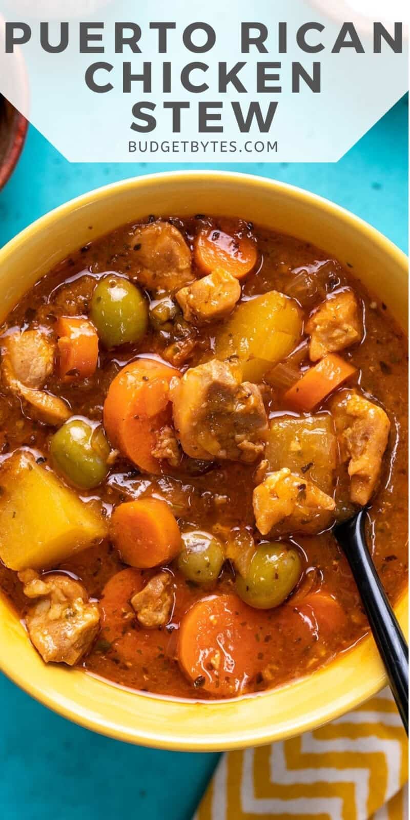 Overhead shot of Guisado de Pollo in a yellow bowl with a spoon in it.