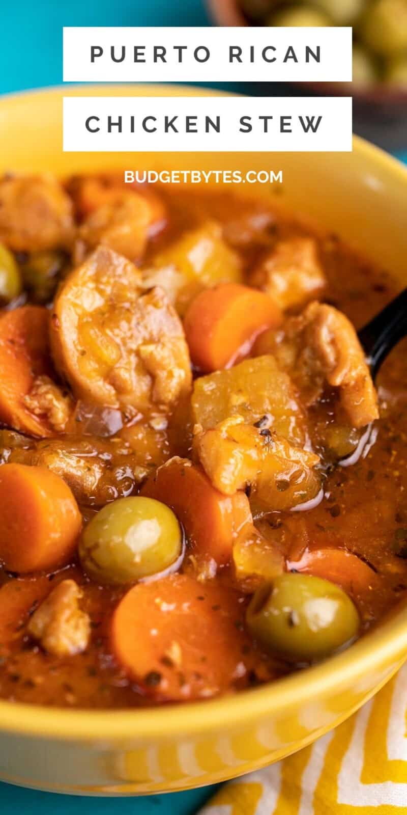 Side shot of Guisado de Pollo in a yellow bowl with a spoon in it.