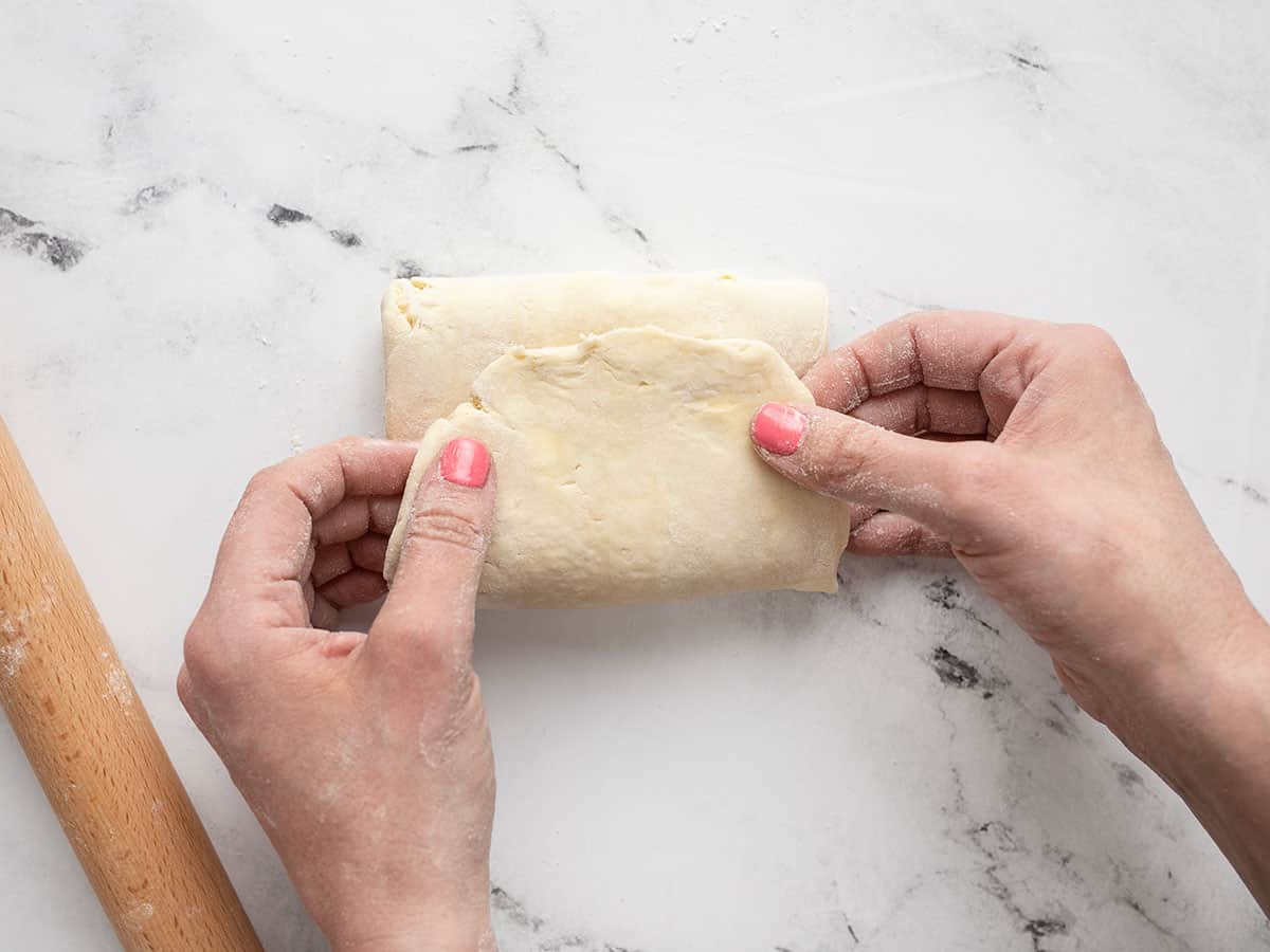 Homemade pie dough being folded into thirds. 