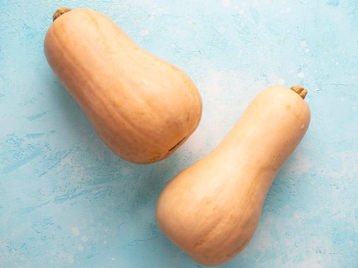 Two butternut squashes on a blue background. 