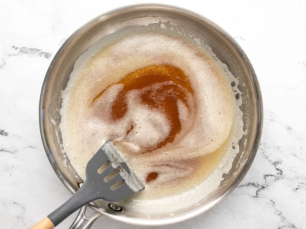 Overhead shot of butter browning in a silver pan.