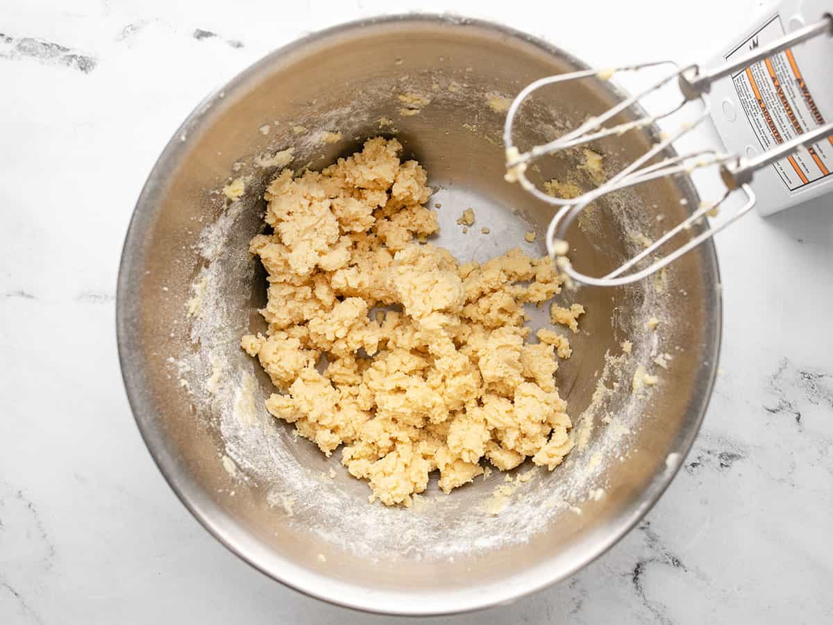 Cookie dough in the bowl with the mixer on the side. 